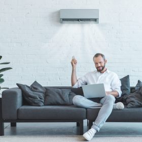 man-relaxing-on-sofa-with-laptop-and-remote-2026-03-13-01-21-06-utc
